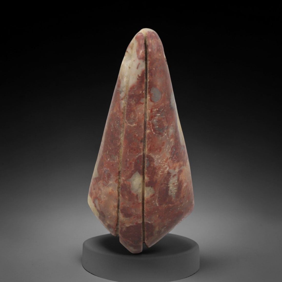 Ancient Red Stone Bud-Form Pendant - Near Eastern Ritual Amulet, 12XQ: Carved from a striking, variegated red stone with natural cream and grey mineral inclusions, this elongated pendant takes the stylized form of a closed floral bud or seed pod, a potent motif in ancien