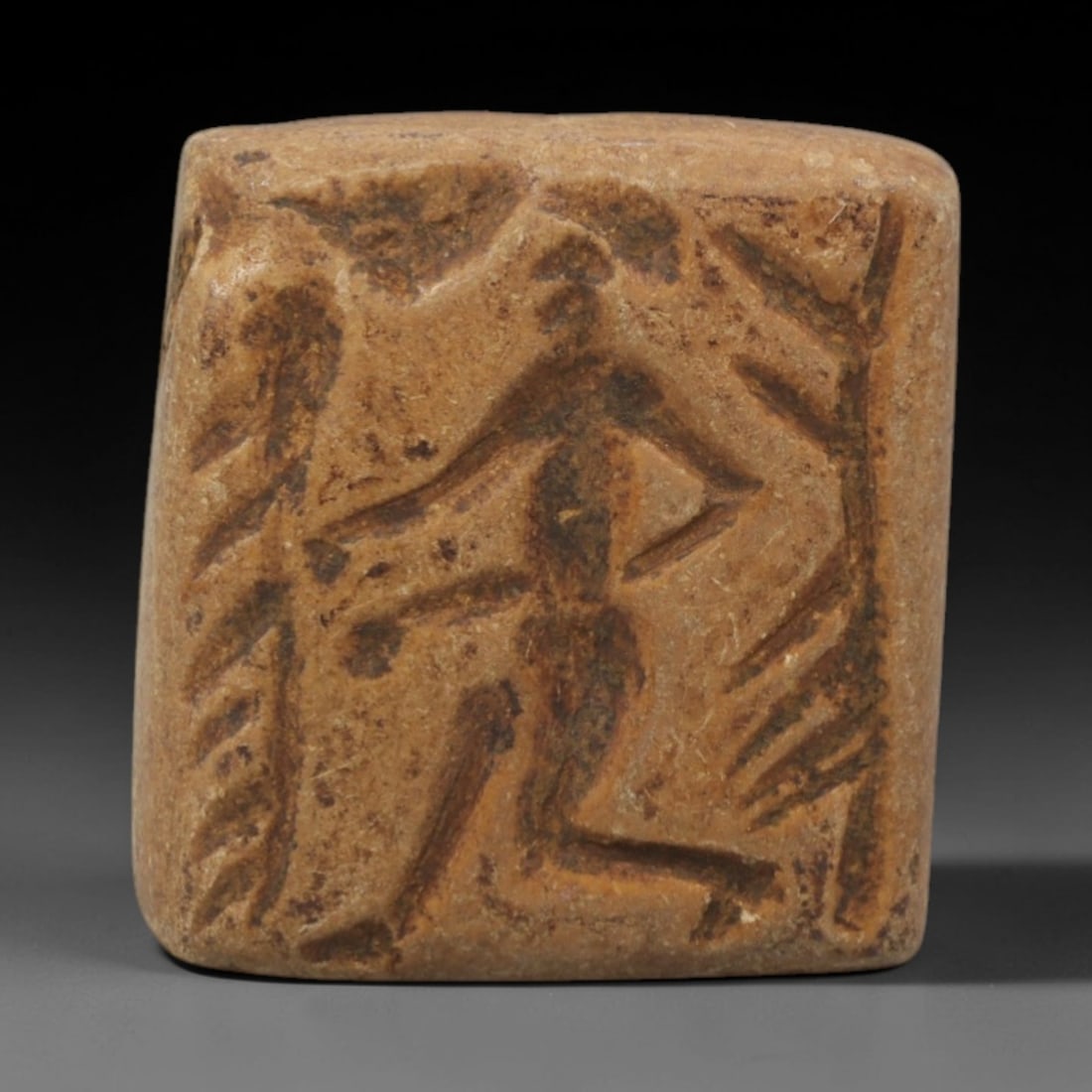 Ancient Steatite Seal Bead - Near Eastern Double Convex Amulet, 15ZQ: Carved from steatite, this double convex seal bead features a standing human figure with incised linear detailing on both faces. The stone exhibits a soft, earthy patina with minor surface wear consis