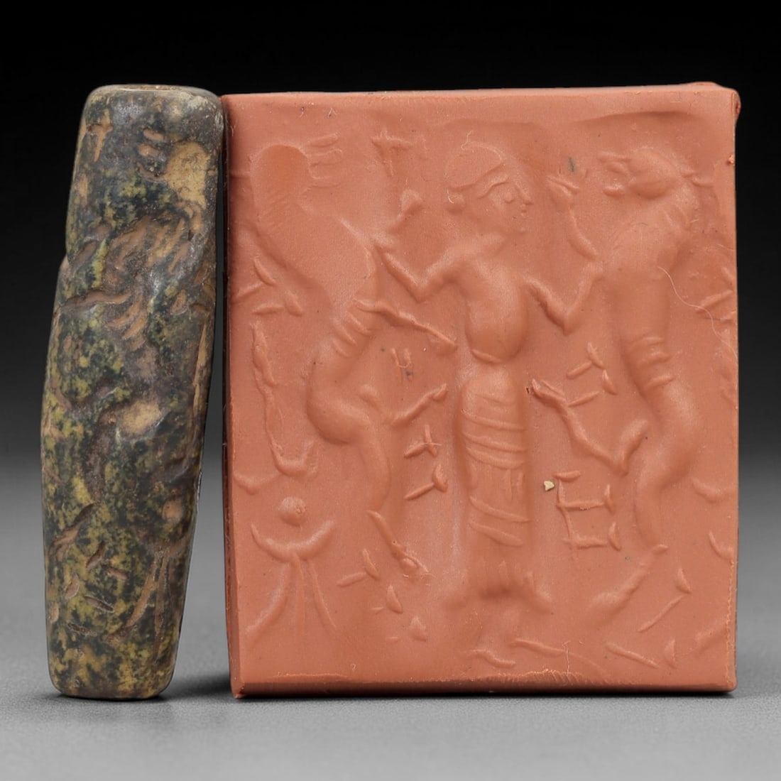 Ancient Steatite Cylinder Seal - Mesopotamian Figural & Mythical Beast Scene, 61AN: Carved from dense steatite, this ancient Mesopotamian cylinder seal features a detailed linear relief composition of a human figure flanked by two mythical beast motifs, executed in the characteristic