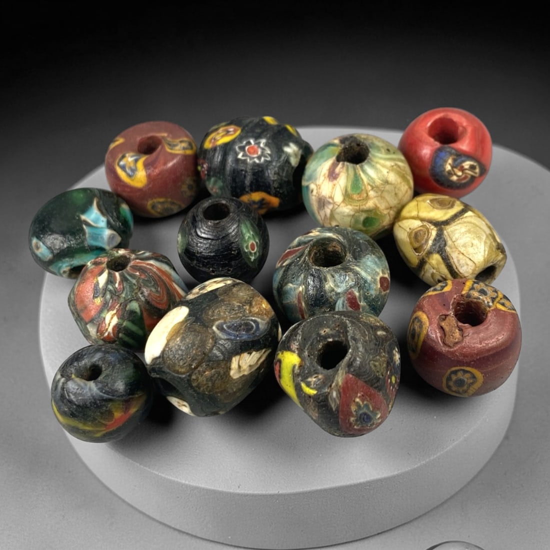 Antique Venetian Glass Beads - 13 Pieces, 12ZT: This set of 13 antique Venetian glass beads showcases hand-formed spherical and irregular shapes, crafted from polychrome glass with intricate mosaic and cane-work patterns characteristic of 19th-cent