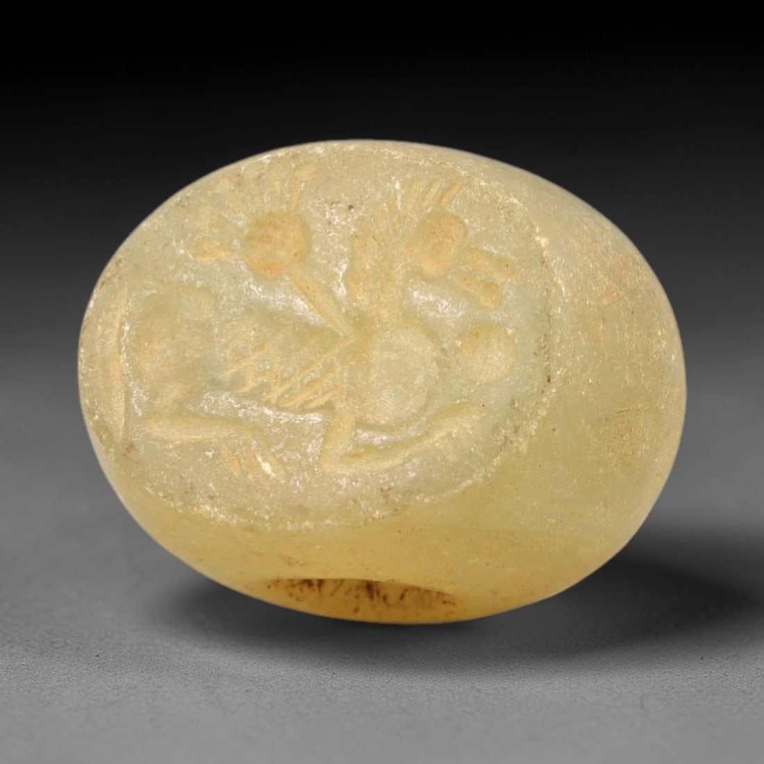 Ancient Chalcedony Hemispherical Stamp Seal - Near Eastern Composite Beast Amulet, 30AN: This ancient Near Eastern hemispherical stamp seal is carved from pale, translucent chalcedony, with a smooth, weathered patina and subtle earthy inclusions. The seal's oval face depicts a composite b