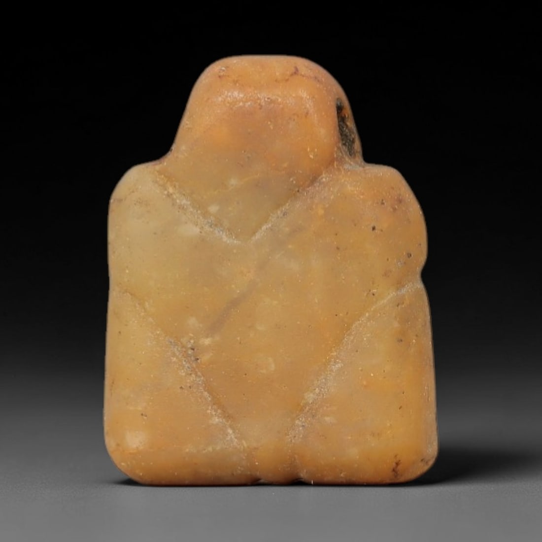 Ancient Stone Eye of Horus Amulet - Egyptian Ritual Figurine, 59AG: This amulet is carved from a single piece of warm amber-hued stone, exhibiting a fine-grained texture with subtle ochre patina and fine mineral veining across its surface. The form is a stylized Eye o