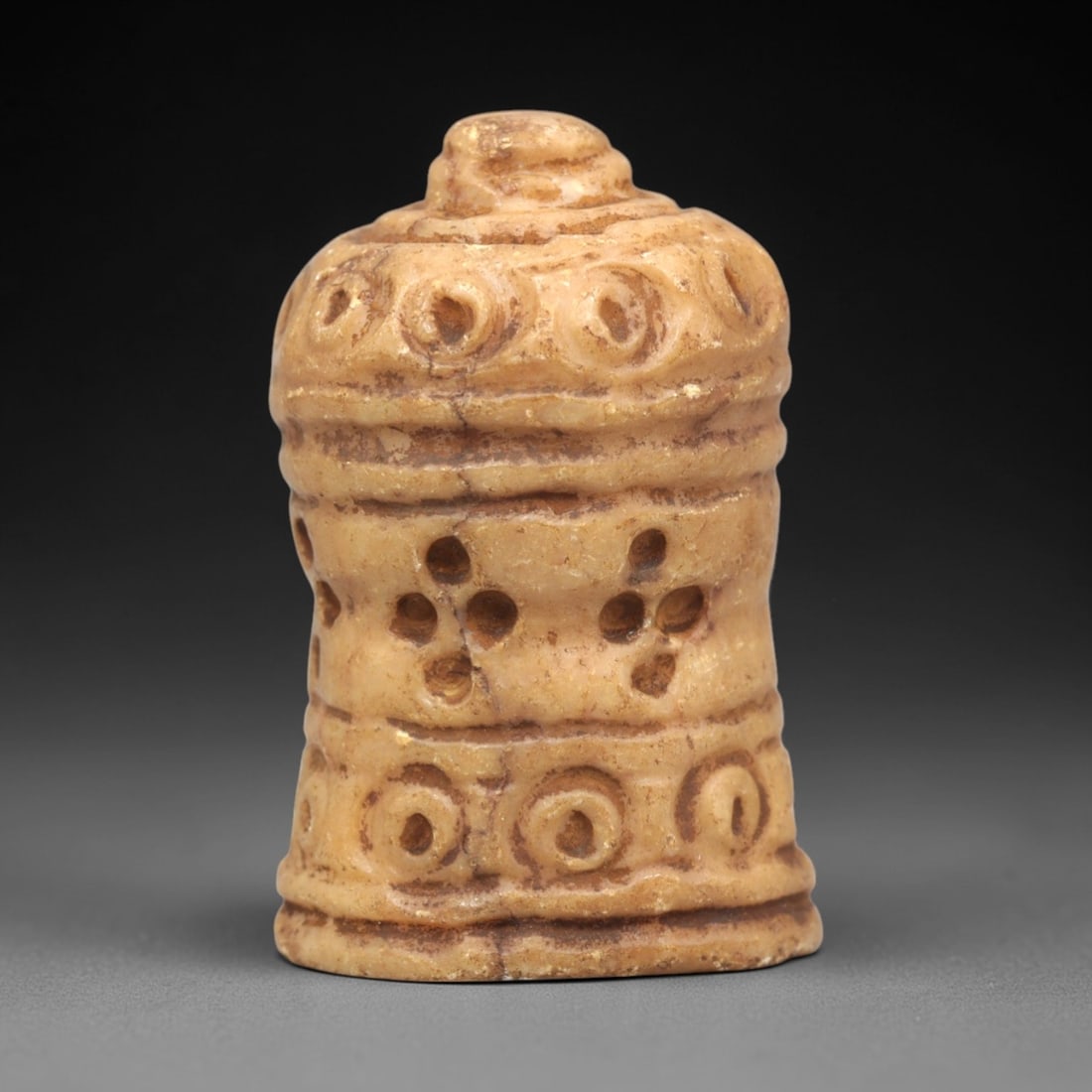 Ancient Stone Chess Piece - Egyptian Islamic Figurine, 3ZR: Carved from light tan stone, this cylindrical chess piece features horizontal ridged bands and symmetrical perforated circular motifs, characteristic of medieval Egyptian Islamic gaming artifacts. The