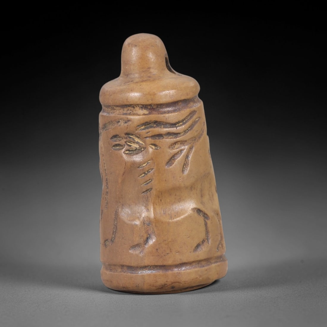Ancient Stone Stamp Seal - Near Eastern Bell Figure, 38AM: This bell-shaped stamp seal is carved from hard stone, featuring incised relief depictions of animal forms and linear motifs across its cylindrical body, consistent with ancient Near Eastern glyptic t