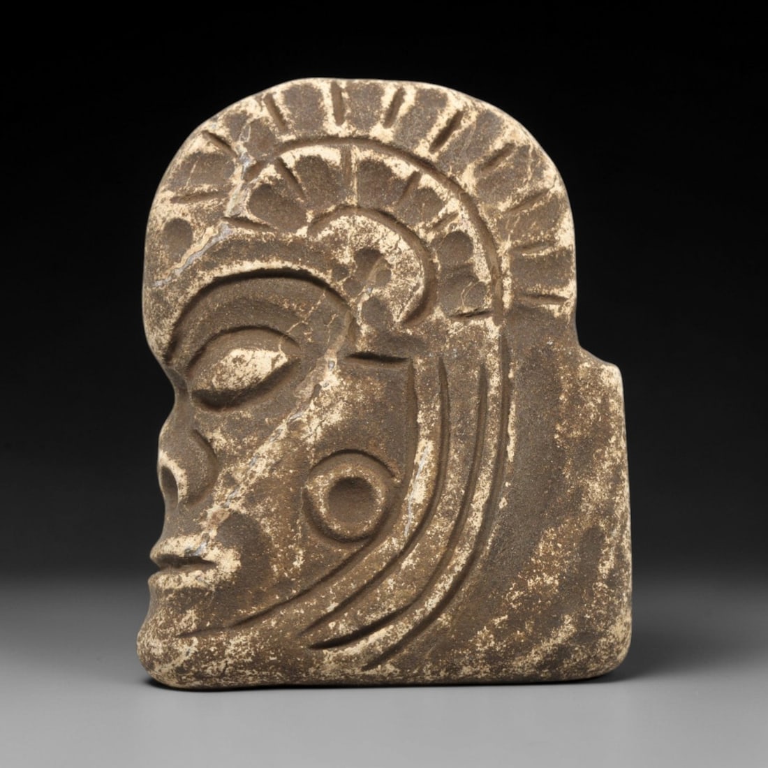 Ancient Stone Anthropomorphic Head - Near Eastern Idol, 72ZV: This artifact is a carved stone anthropomorphic head, crafted from a granular, earth-toned stone consistent with ancient Near Eastern lithic traditions. The relief carving depicts a stylized profile f
