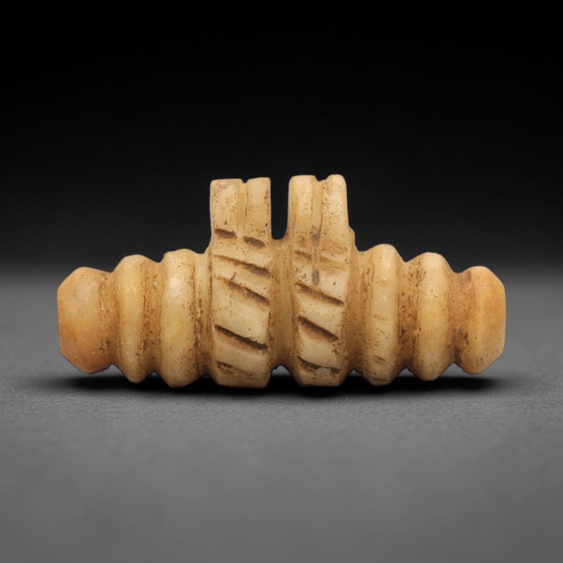 Ancient Achaemenid Stone Amulet - Near Eastern Figurine, 24ZR: This artifact is a carved stone amulet, executed in the geometric decorative tradition of the ancient Achaemenid Persian Empire. The amulet features a symmetrical, cylindrical form with concentric rid