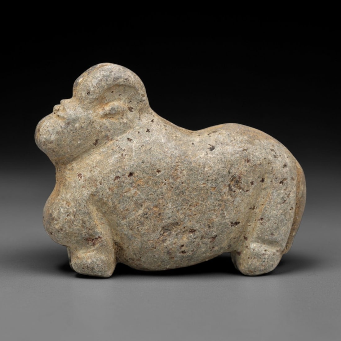 Ancient Stone Zoomorphic - Near Eastern Animal Figurine, 36ZR: Carved from dense speckled grey-brown stone with a heavily weathered earthy patina, executed in a robust, stylized form characteristic of ancient Near Eastern zoomorphic craftsmanship. The figure depi
