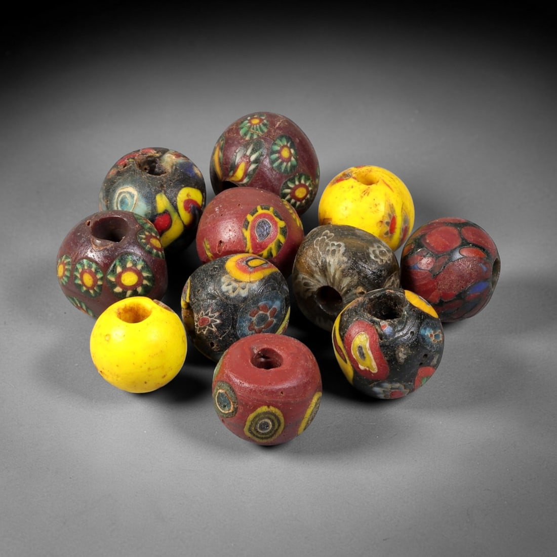 Antique Venetian Glass Trade Beads - Multicolor Set, 59FX: This group of eleven antique Venetian glass trade beads is crafted from hand-worked glass, featuring vibrant layered, mosaic, and eye-style patterns in hues of red, green, yellow, black, and blue. Eac