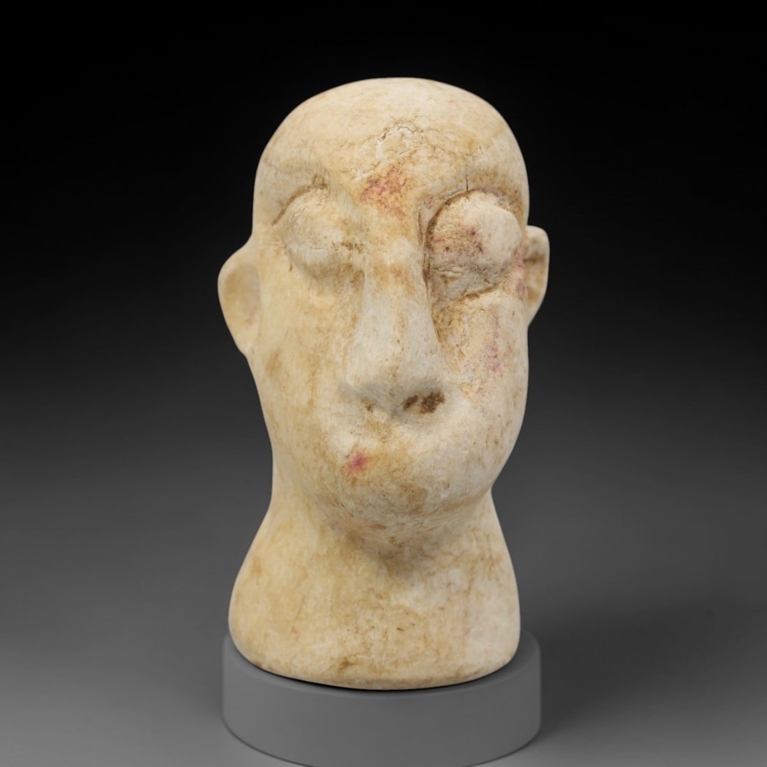 Ancient Limestone Idol Head - Bactrian Carved Figurine, 52ZQ: Carved from limestone, this ancient Bactrian idol head features a stylized human facial form with detailed eye and mouth motifs, typical of Bactrian artistic traditions. The carving exhibits moderate