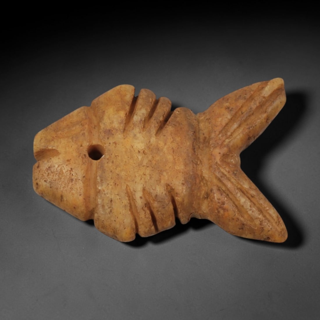 Ancient Yellow Stone Fish - Near Eastern Zoomorphic Amulet, 76XP: Carved from fine-grained yellow stone, this miniature zoomorphic amulet depicts a stylized fish, a motif rich in symbolic connotations across ancient Near Eastern cultures, often associated with water