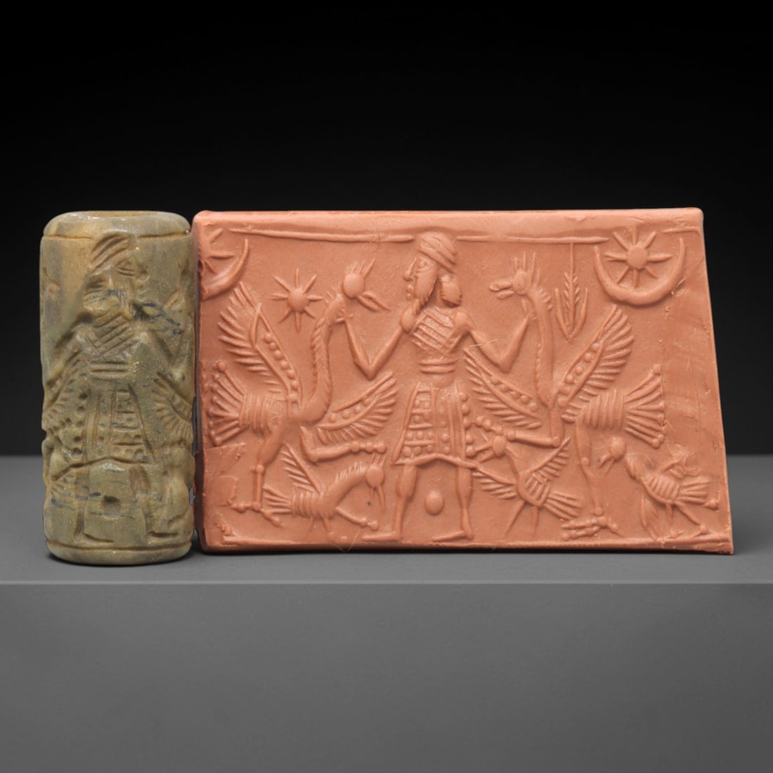Ancient Steatite Cylinder Seal - Mesopotamian Deity & Winged Avian Ritual Scene, 52AL: Carved from muted, variegated steatite, this ancient cylinder seal depicts a solemn divine ritual scene, executed with meticulous glyptic craftsmanship characteristic of the Neo-Assyrian period. The c