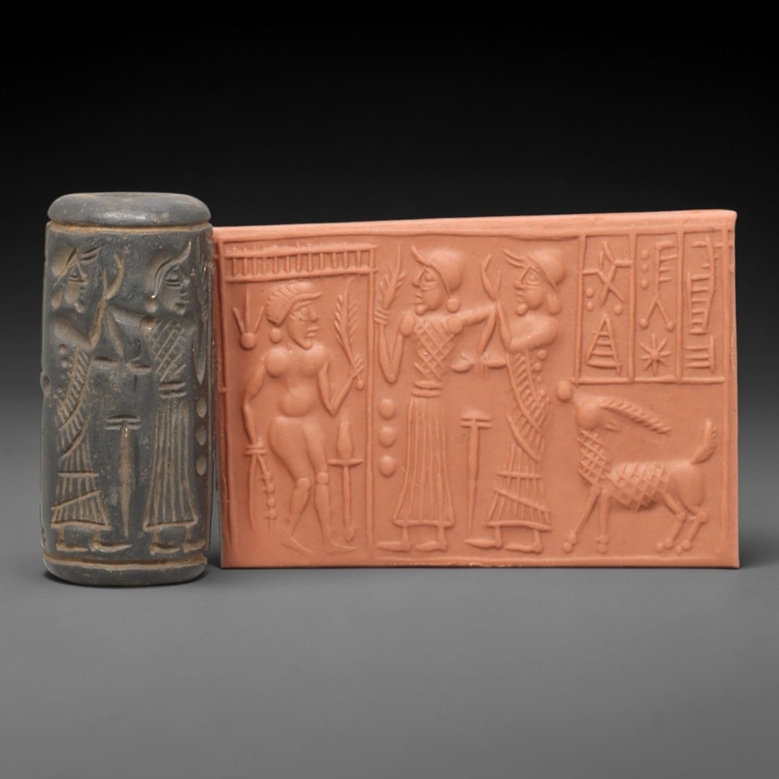 Ancient Steatite Cylinder Seal - Mesopotamian Administrative & Ritual Scene, 34AL: Carved from dark, weathered steatite, this ancient Mesopotamian cylinder seal depicts a detailed administrative and ritual scene, executed with precise glyptic craftsmanship characteristic of the Neo-