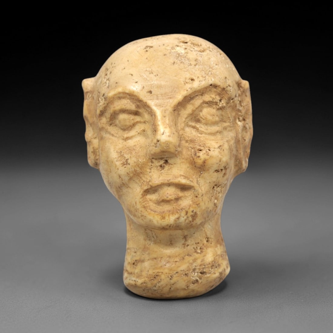 Ancient Stone Bactrian Idol Head - Central Asian Figurine, 74ZP: This artifact is a complete carved stone head of a Bactrian idol, executed in the stylized anthropomorphic tradition of ancient Central Asian Bactrian culture. The head features distinct facial featur