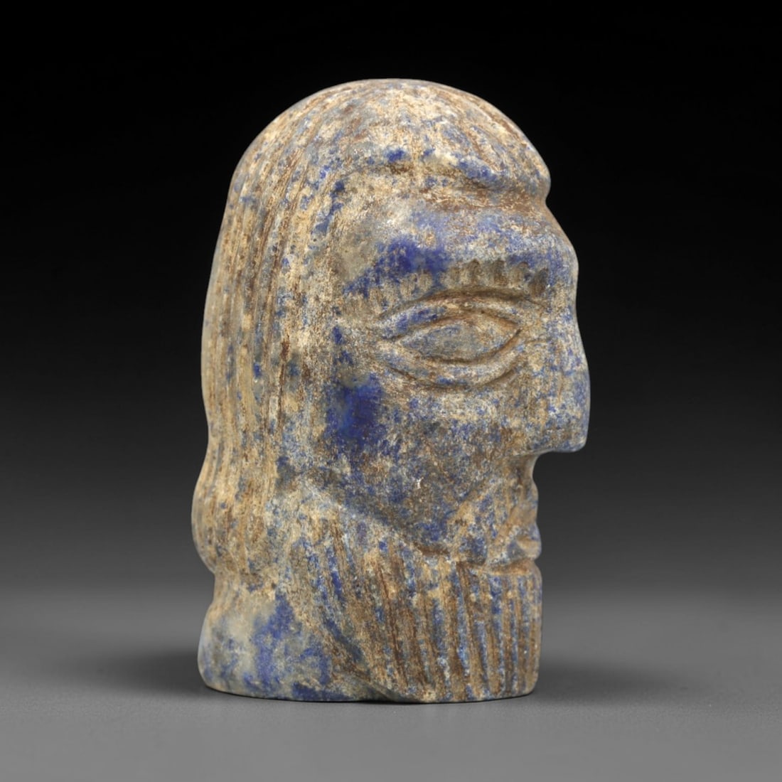 Ancient Lapis Lazuli Bust - Near Eastern Male Figurine, 29ZS: This artifact is a complete carved lapis lazuli bust of a male figure, executed in the stylized sculptural tradition of the ancient Near East. The bust features a profile view with distinct facial ele