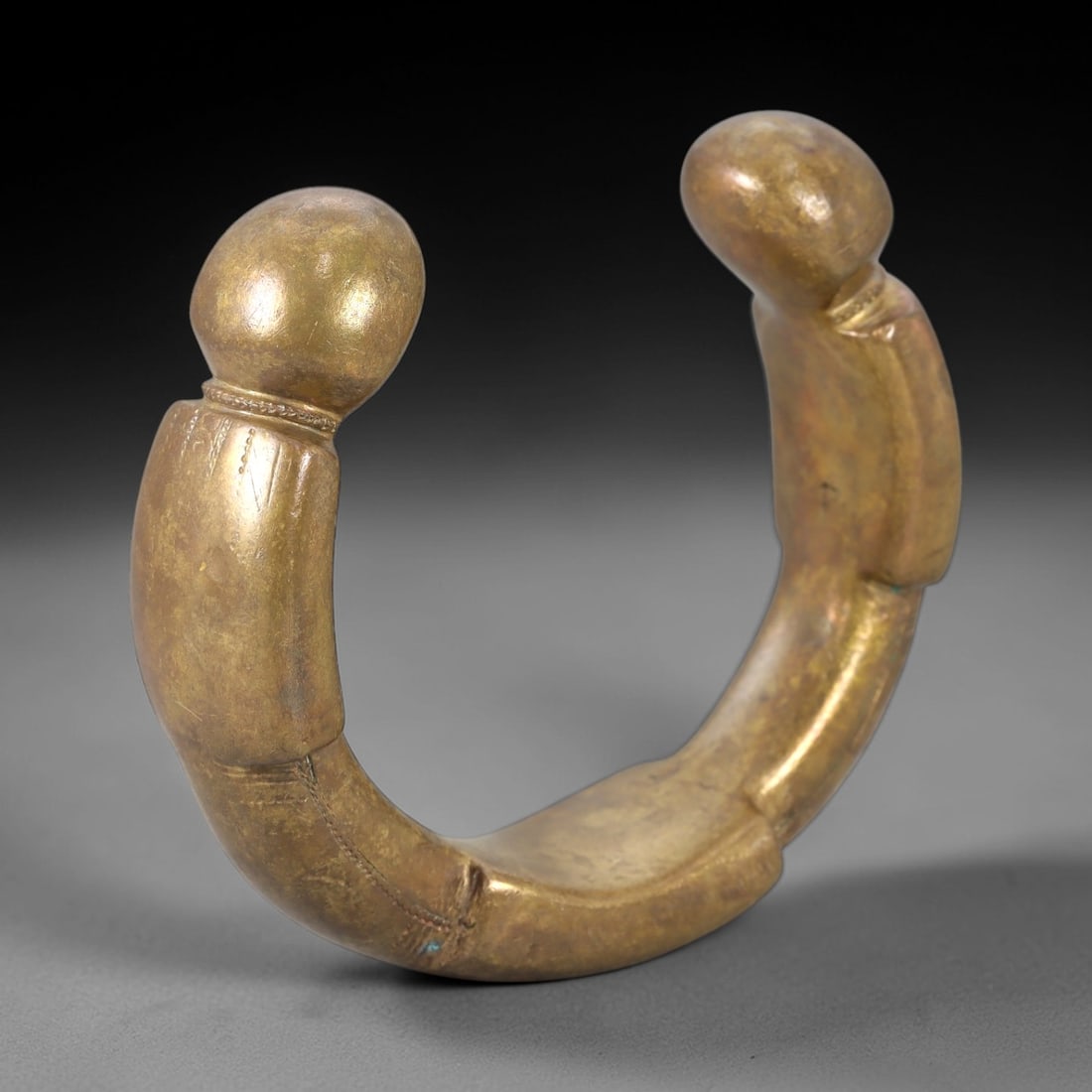 African Bronze Queen Manilla - West African Bracelet Currency, 95FW: Cast from golden-brown bronze, this 6.5cm diameter manilla (bracelet currency) features a robust C-shaped form with two bulbous terminal ends, each adorned with subtle incised linear details and decor