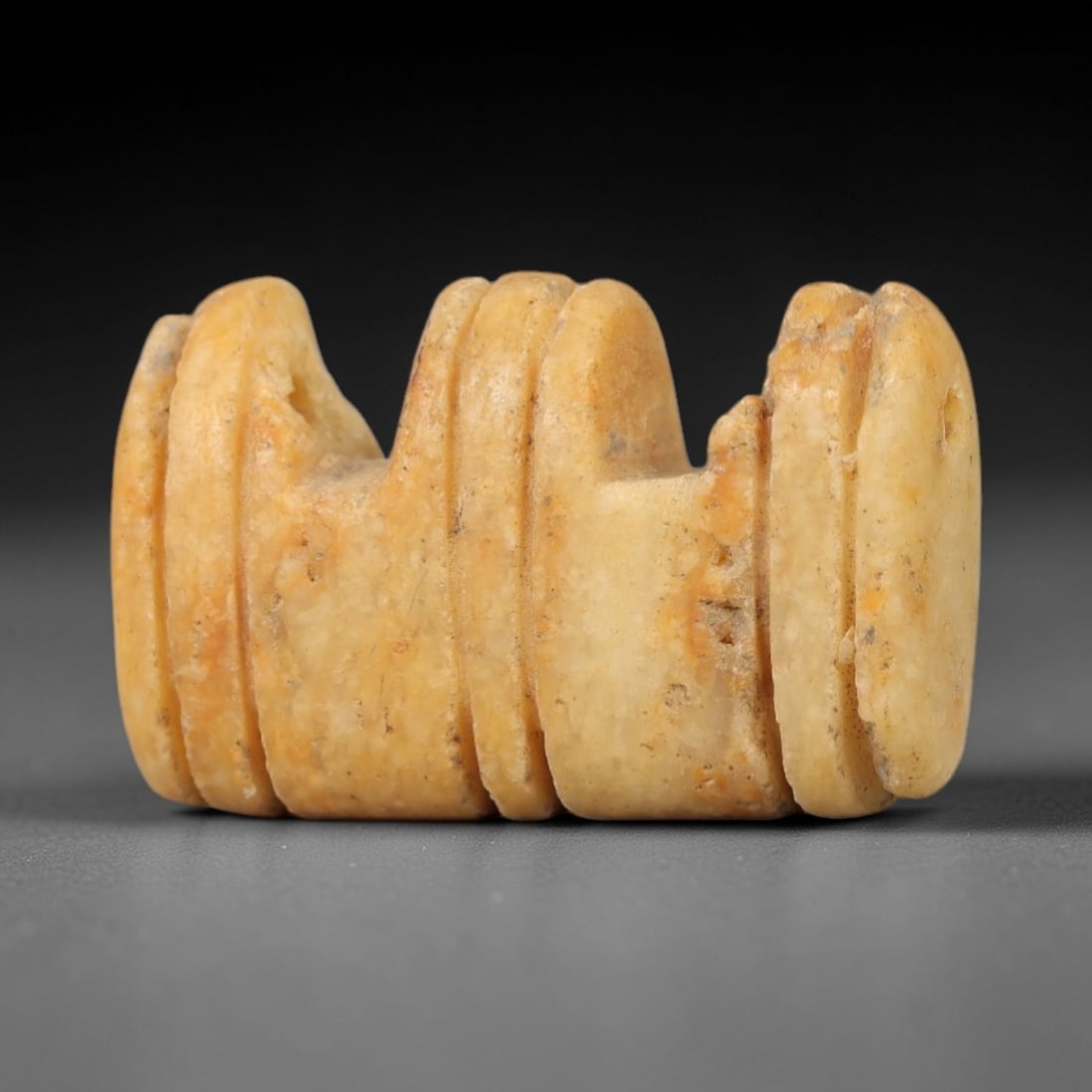Ancient Stone Tyet Amulet - Egyptian Ritual Figurine, 7AG: This amulet is carved from a single piece of pale tan stone, exhibiting a fine-grained texture with subtle ochre patina and faint mineral inclusions across its surface. The form is a stylized Tyet (or