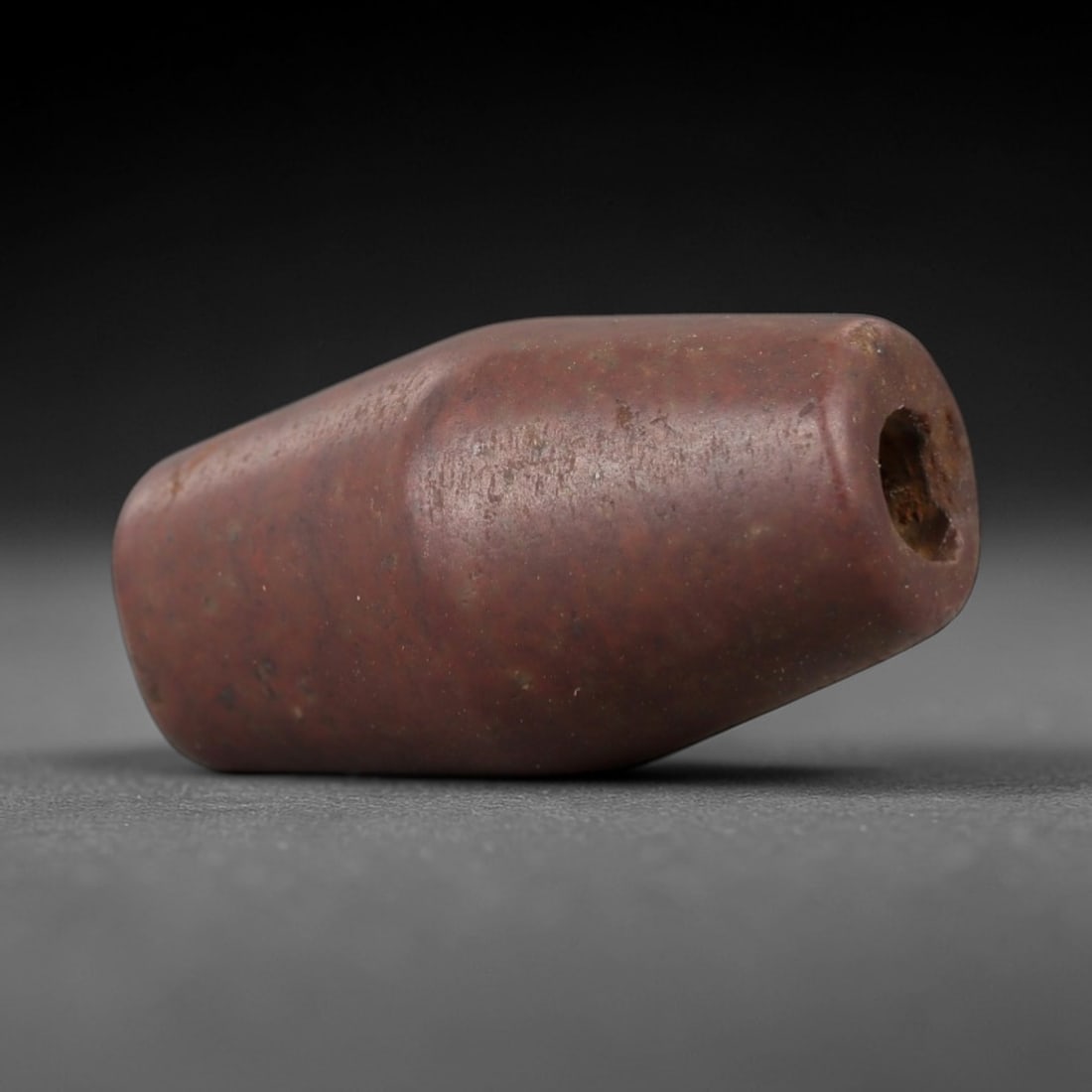 Ancient Stone Cylindrical Amulet - Near Eastern Ritual Figurine, 49AG: This amulet is carved from a single piece of deep reddish-brown stone, exhibiting a fine-grained texture with subtle ochre patina and faint mineral veining across its surface. The form is a compact, s