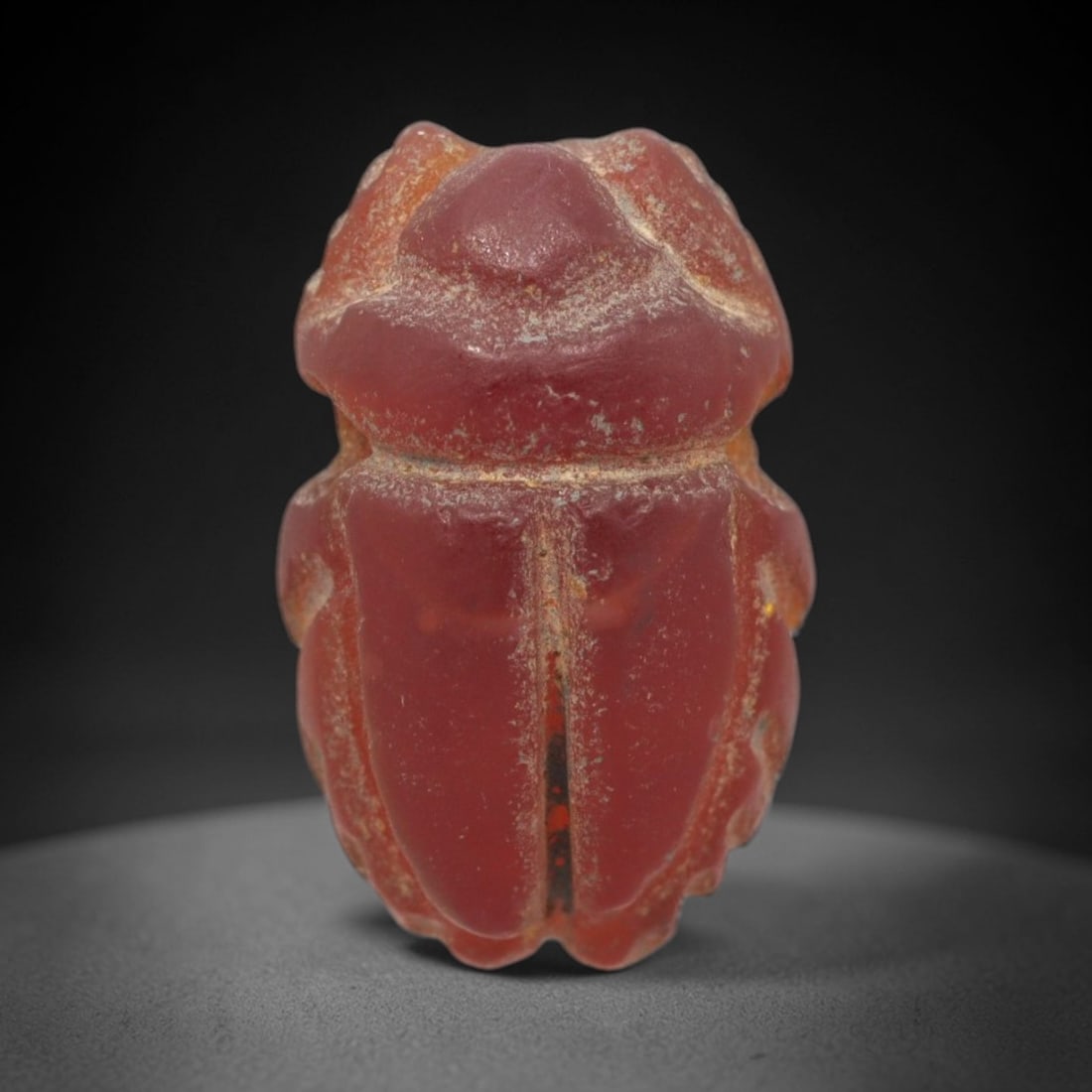 Ancient Carnelian Scarab - Egyptian Amulet Bead, 91XS: This amulet is carved from rich deep red carnelian, exhibiting the characteristic translucency and warm hue of ancient Egyptian glyptic craftsmanship. The form is a classic scarab beetle, with defined