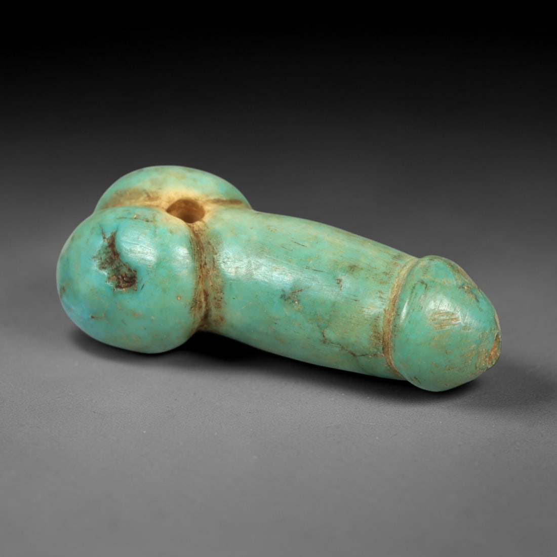 Ancient Turquoise Phallic Amulet - Near Eastern / Egyptian Protective & Fertility Relic, 79AK: This small, finely carved ancient amulet is fashioned from natural turquoise, shaped in a stylized phallic form with a smooth, tapered body and subtle detailing at the base and tip. A tiny vertical su