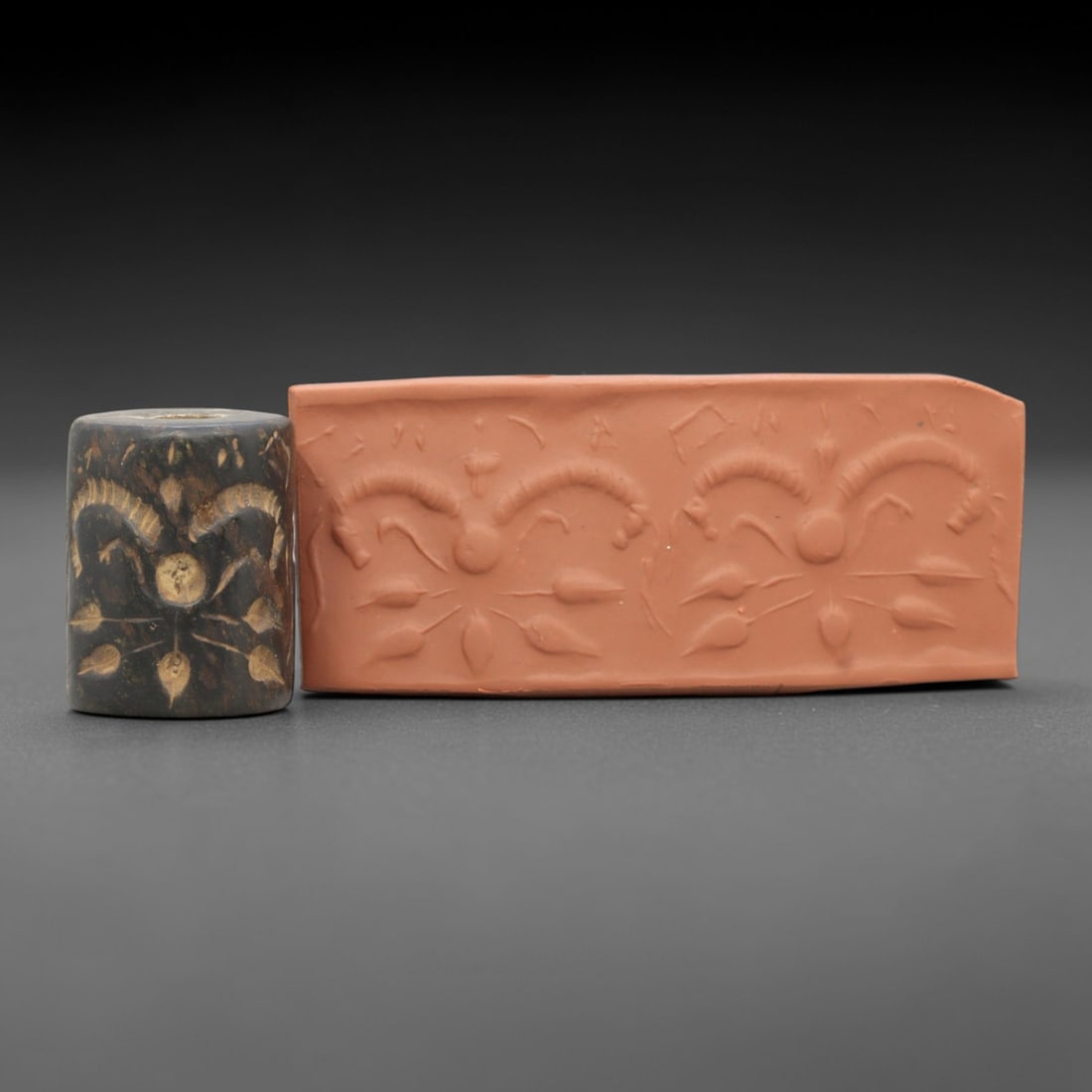 Ancient Steatite Cylinder Seal - Mesopotamian Symmetrical Botanical Motif, 97ZR: Carved from dense steatite, this ancient Mesopotamian cylinder seal features a precise symmetrical relief composition of repeated botanical and curvilinear motifs, executed in the characteristic glypt
