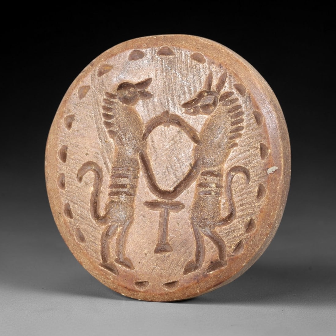 Ancient Steatite Stamp Seal - Near Eastern Bovid Amulet, 53AS: This ancient Near Eastern stamp seal is carved from steatite, presenting a circular form with incised decoration depicting two confronting bovid figures in a stylized, archaic manner characteristic of