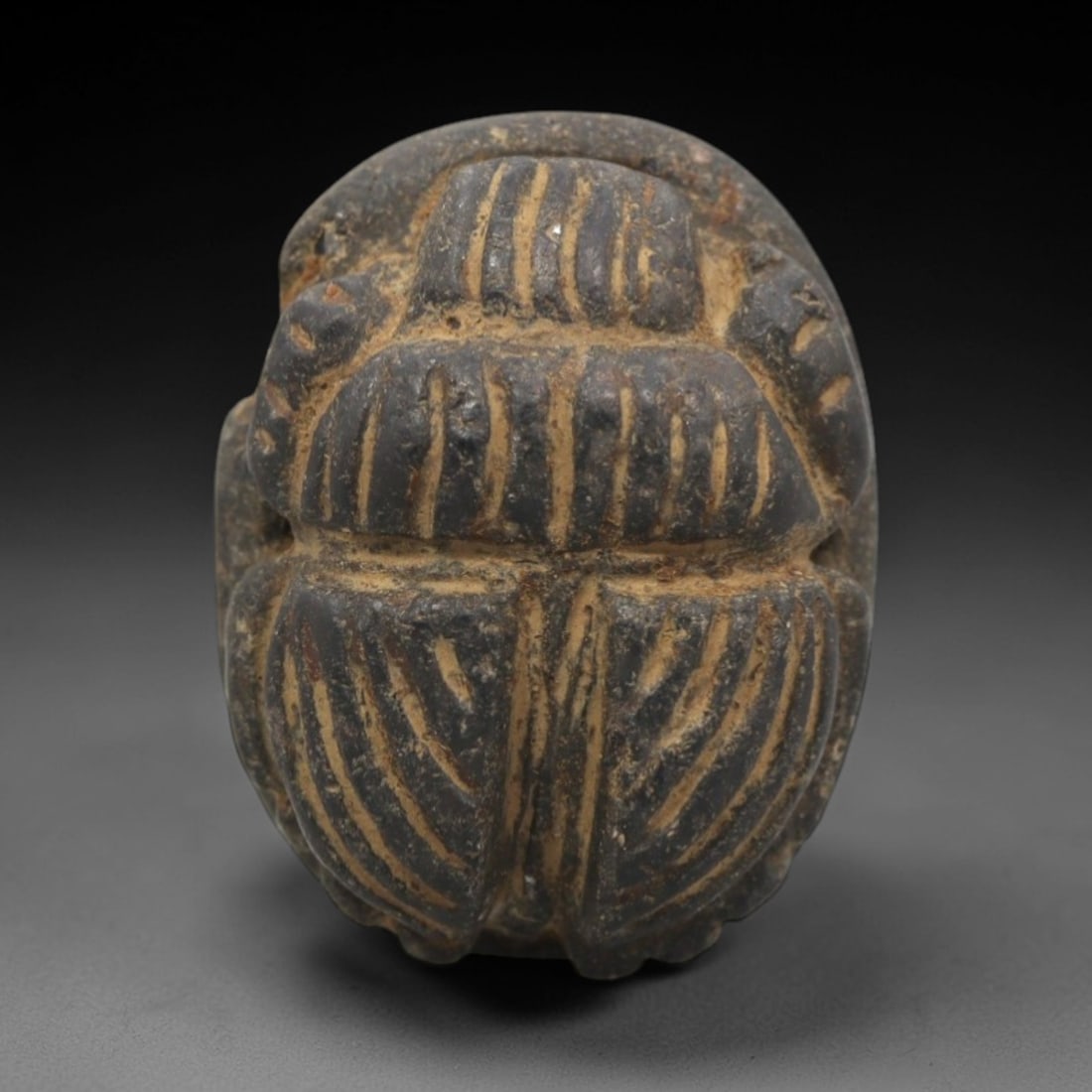 Ancient Steatite Scarab Stamp Seal - Near Eastern Anthropomorphic Figure, 49ZR: Carved from dark steatite with golden-brown incised patination, this Near Eastern scarab stamp seal features a dorsal scarab pattern with deeply incised linear elytra segments defining the beetle's fo