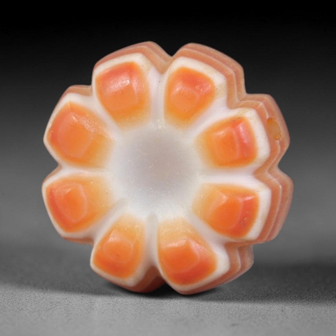 Antique Agate Flower Bead - Central Asian Carved Gemstone, 11AR: Carved from banded agate with creamy white and warm orange natural banding, this bead features a symmetrical eight-petaled floral form with faceted, raised orange petals and a hollow central cavity. A