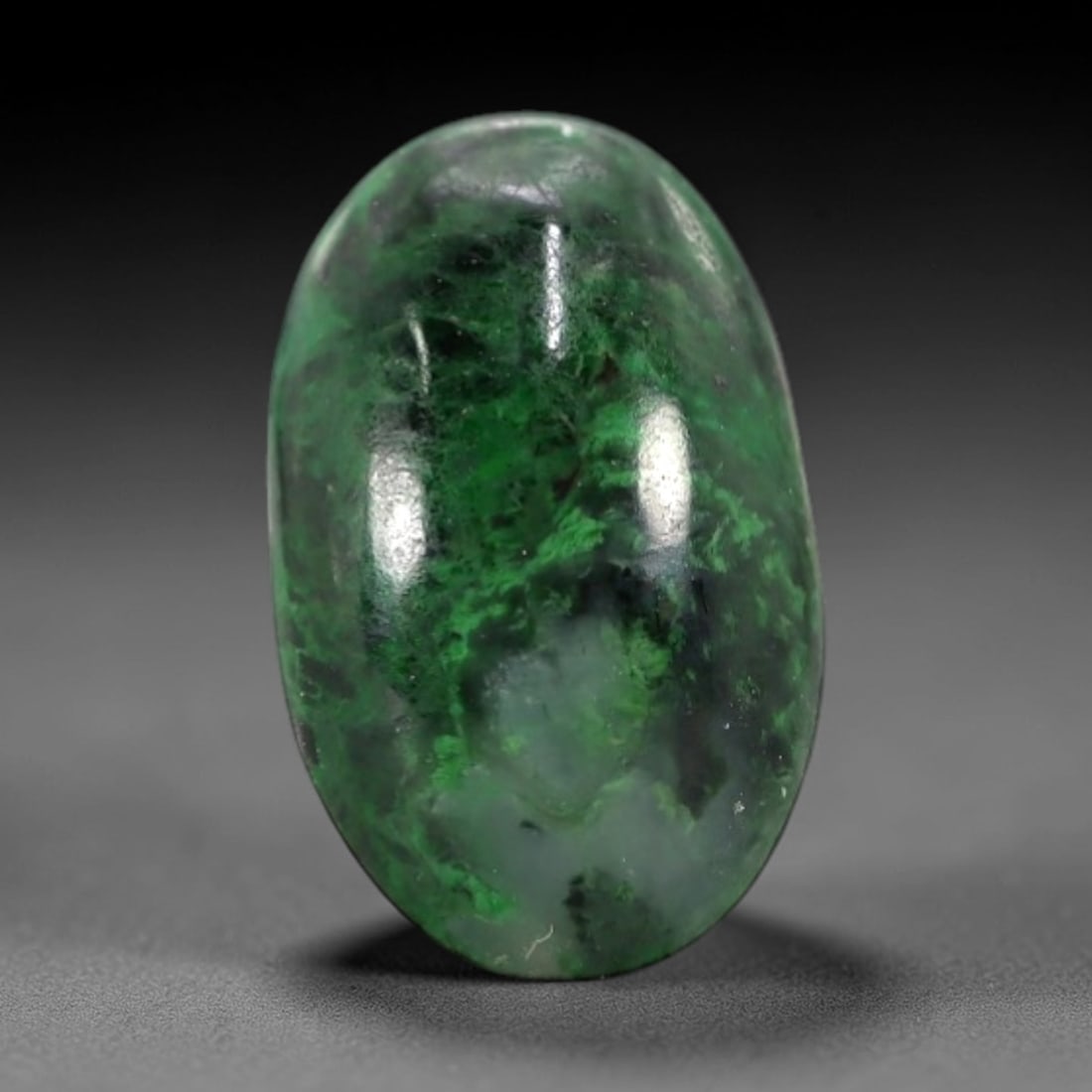 1.97 Carats Deep Green and Pale Matrix Maw Sit Sit Jade Cabochon - Natural Burmese Stone, 1AB: This maw sit sit jade cabochon is fashioned into an oval, domed form with a highly polished surface. The material exhibits a deep, saturated green matrix, interspersed with a pale, semi-translucent to