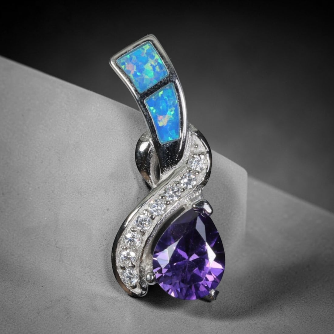 3.63g 925 Sterling Silver Swirl Pendant - Simulated Opal Amethyst, 48D: Crafted from stamped 925 sterling silver, this pendant features an elegant swirling openwork design. Two rectangular segments of simulated opal are inlaid along the upper curved silver band, exhibitin