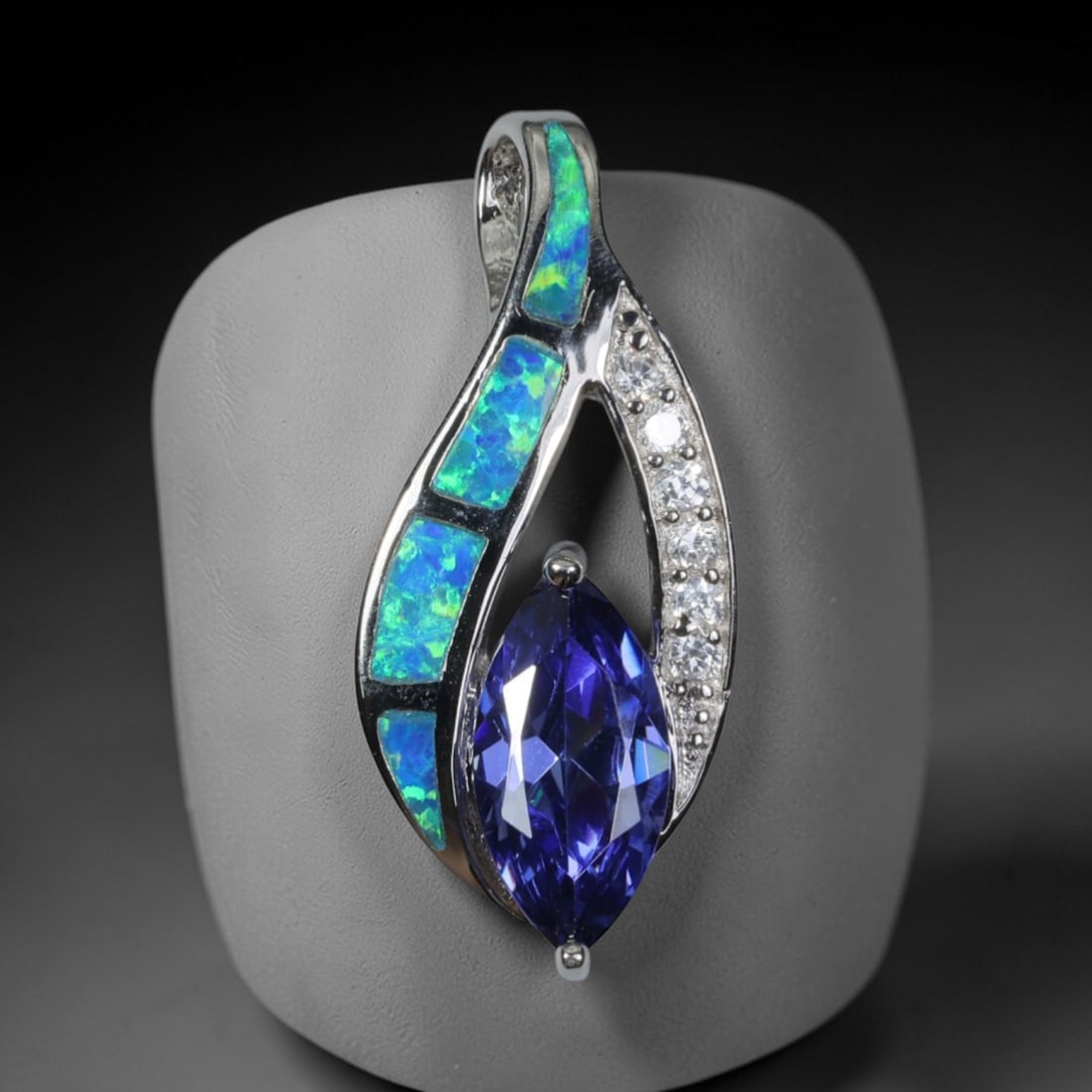 4.17g 925 Sterling Silver Leaf Pendant - Simulated Opal Iolite, 36D: Crafted from stamped 925 sterling silver, this pendant features an elegant leaf-shaped openwork design. Four rectangular segments of simulated opal are inlaid along one curved edge, exhibiting vivid i