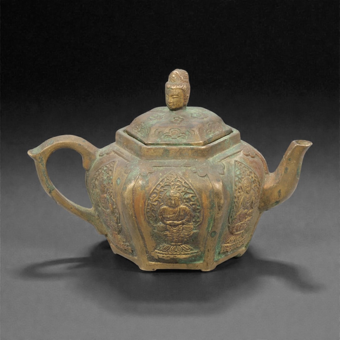 A Chinese Bronze Teapot, 20th Century, 95YC: Cast in bronze, the teapot is formed with a faceted globular body divided into vertical panels, each enclosing a relief-decorated figural or ornamental motif. It is fitted with a curved spout, an open