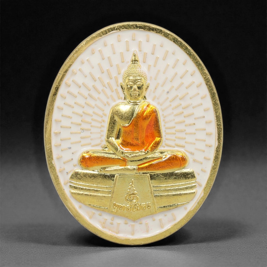 A Thai Gilt-Metal Buddha Medallion, 21st Century, 68FP: Composed of a cast metal core with a gilt surface finish, the medallion is circular and double-sided. The obverse features a polychrome enameled design on a white ground, depicting a seated Buddha fig