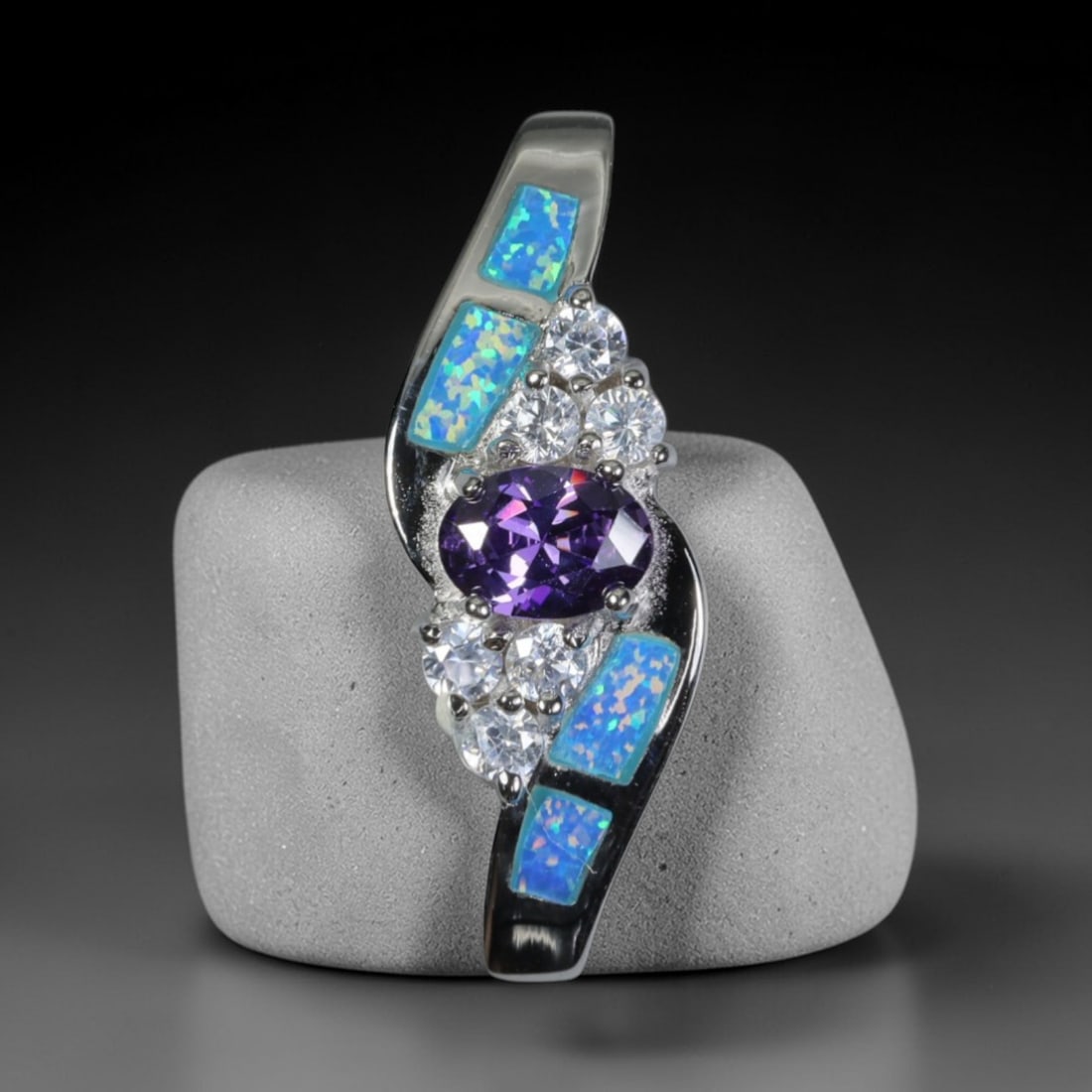 4.42g 925 Sterling Silver Swirl Pendant - Simulated Opal Amethyst, 32D: Crafted from stamped 925 sterling silver, this pendant features a dynamic swirling openwork design. Four rectangular segments of simulated opal are inlaid along the curved silver edges, exhibiting viv