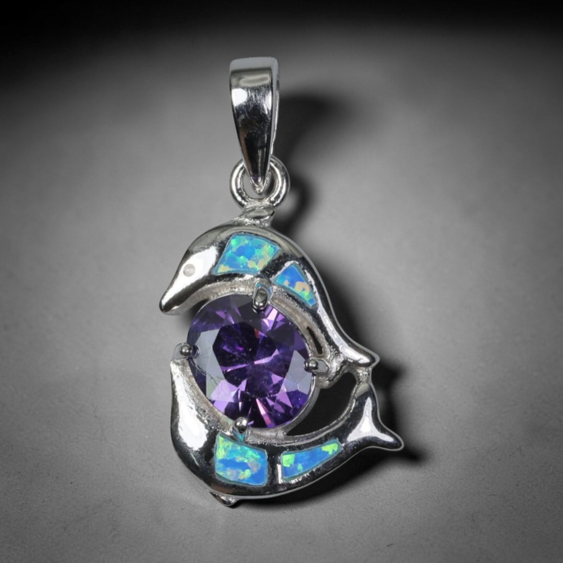 3.77g 925 Sterling Silver Dolphin Pendant - Simulated Opal Amethyst, 50D: Crafted from stamped 925 sterling silver, this pendant features a playful dolphin-shaped openwork design wrapping around a central gemstone. Four rectangular segments of simulated opal are inlaid alon