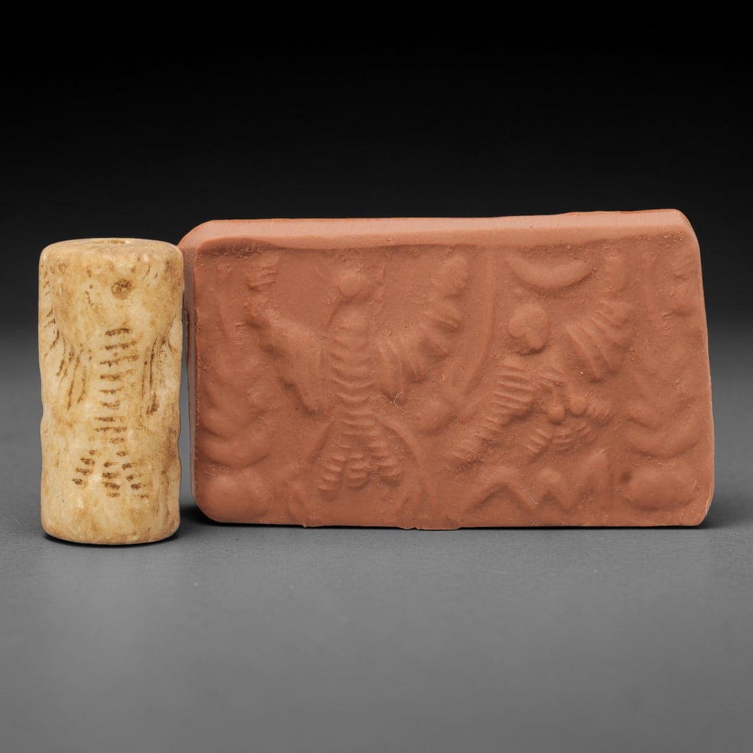 Ancient Calcite Cylinder Seal - Near Eastern Glyptic Art, 49ZQ: Carved from calcite stone, this ancient Near Eastern cylinder seal features a cylindrical form with raised relief carvings depicting stylized animal figures and geometric patterns. The seal exhibits f