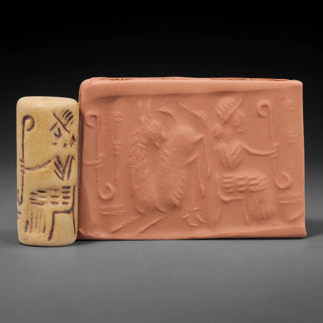 A Mesopotamian Stone Cylinder Seal, Circa 2nd Millennium BCE, 8FT: Carved from a light yellowish-tan fine-grained stone with a polished surface, the object is a cylindrical seal featuring a fully drilled central perforation for suspension and use. The exterior bears