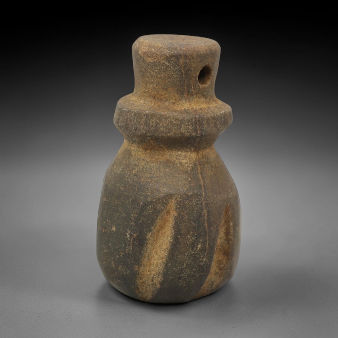 Ancient Stone Abstract Totemic Amulet - Near Eastern Pendant, 23XQ: Carved from a dark grey stone with natural lighter linear veining, this amulet presents a compact, totemic form with a cylindrical head pierced for suspension, a distinct collar neck, and a bulbous, s