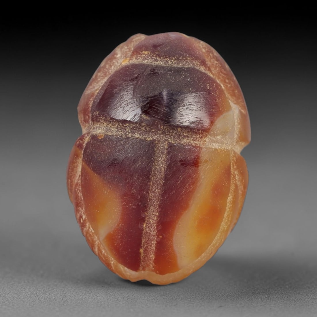 Ancient Banded Agate Scarab Amulet - Egyptian Figurine, 16AJ: Carved from striking banded agate with deep red-brown and warm amber-orange natural layers, this amulet is formed as a stylized scarab beetle with incised linear detailing to define segmented wing cas