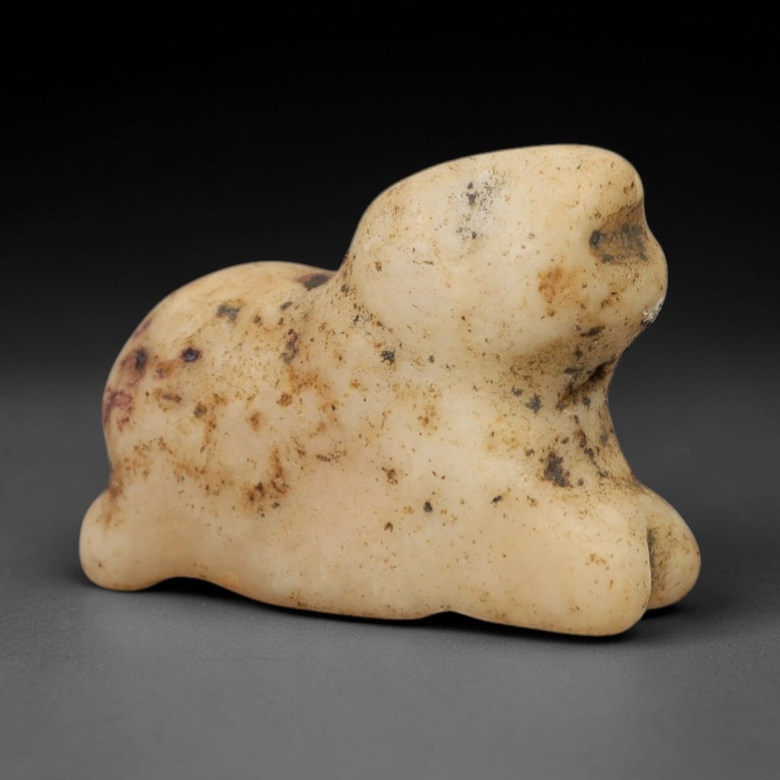 Ancient Limestone Cub Amulet - Miniature Relic, 17AH: Carved from limestone, this ancient cub amulet features a stylized animal form with subtle facial and body detailing typical of regional artistic traditions. The stone exhibits a muted earthy hue with