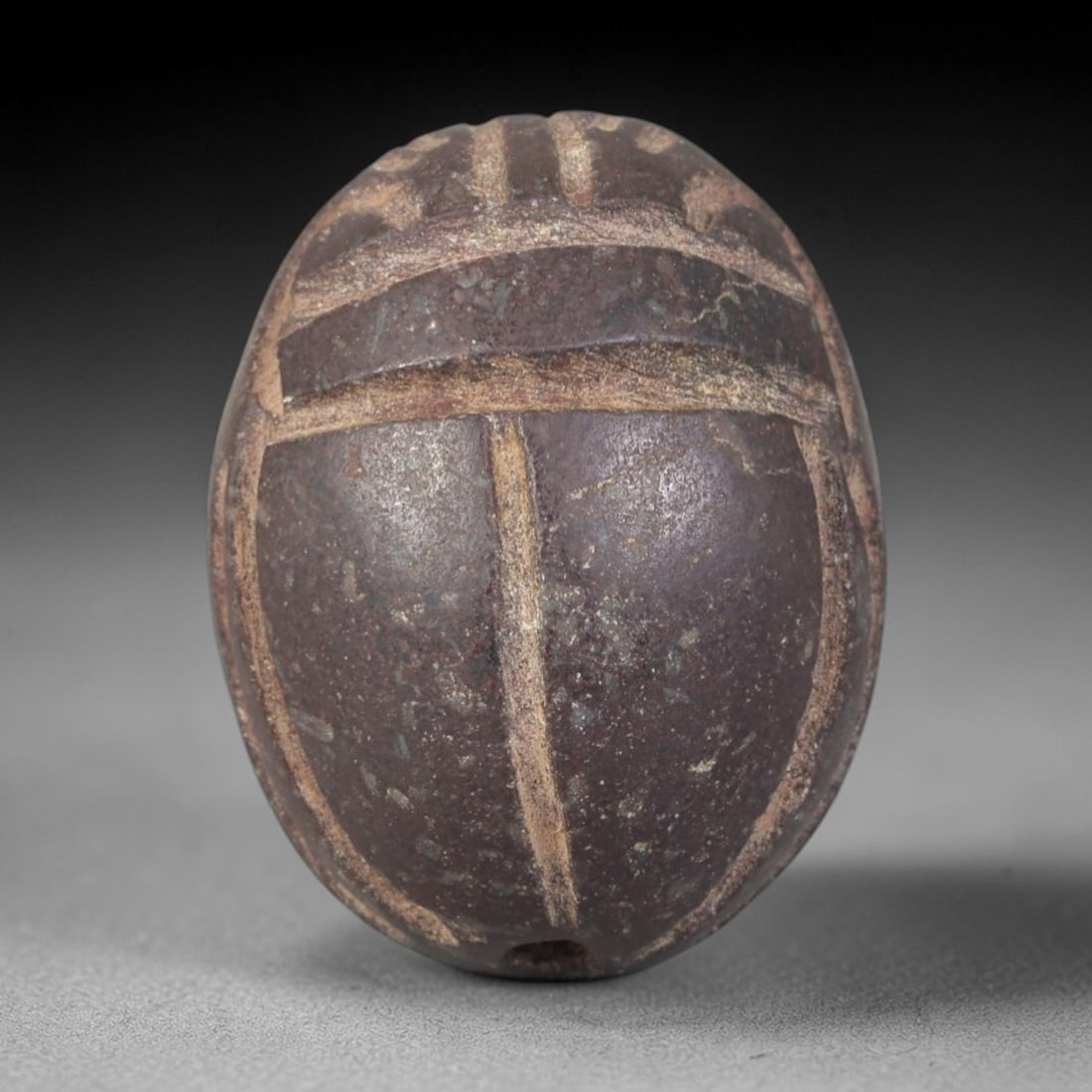 Ancient Steatite Scarab Amulet - Egyptian Figurine, 36AP: This artifact is carved from dark reddish-brown steatite, exhibiting a granular, matte finish with subtle surface wear and mineral inclusions consistent with age. The form is a classic scarab amulet,