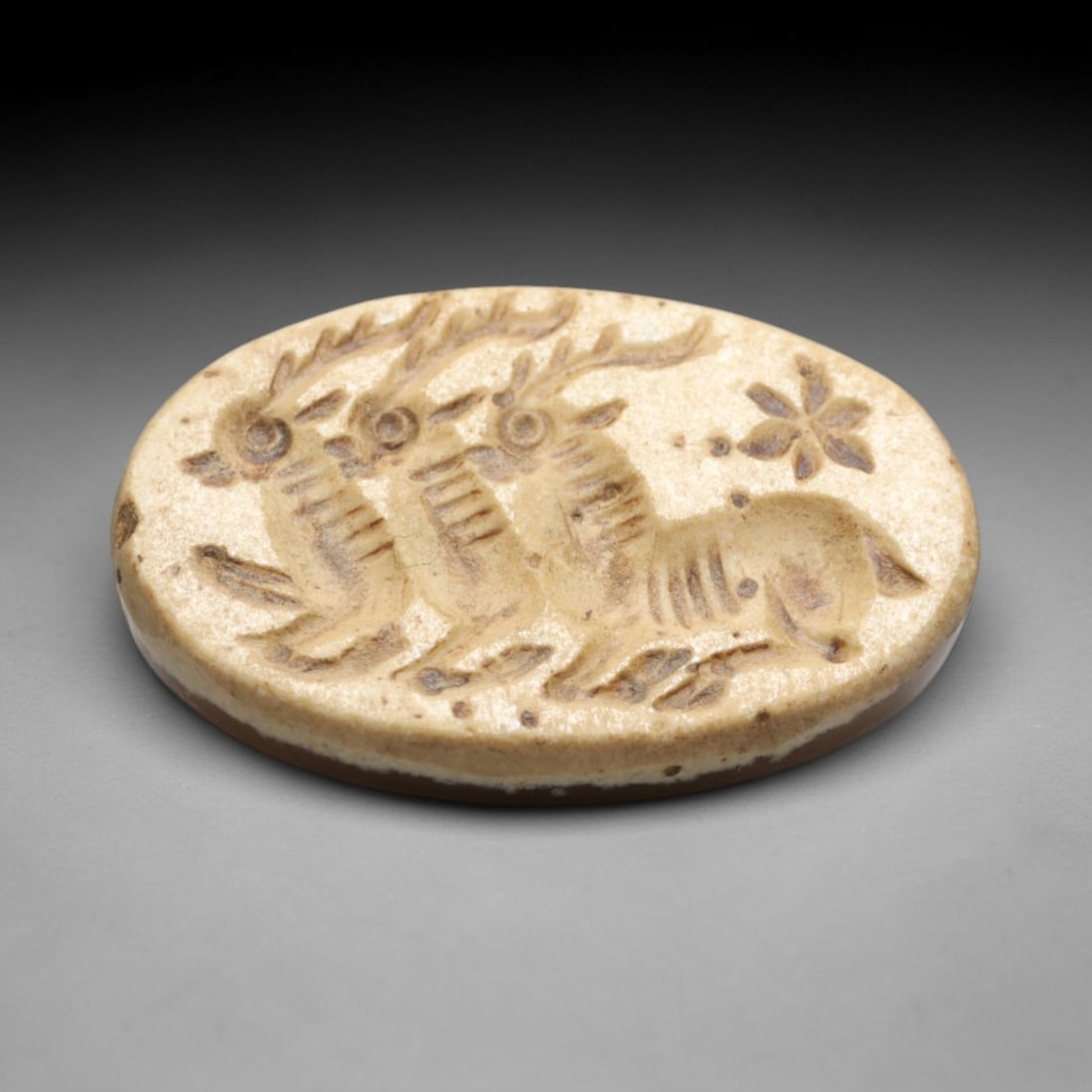 Ancient Agate Intaglio Bead - Near Eastern Three Ibex Motif, 24ZW: Carved from warm banded agate, this oval intaglio bead features a recessed depiction of three ibexes with branching antlers, accompanied by a star-like floral motif, characteristic of ancient Near Eas