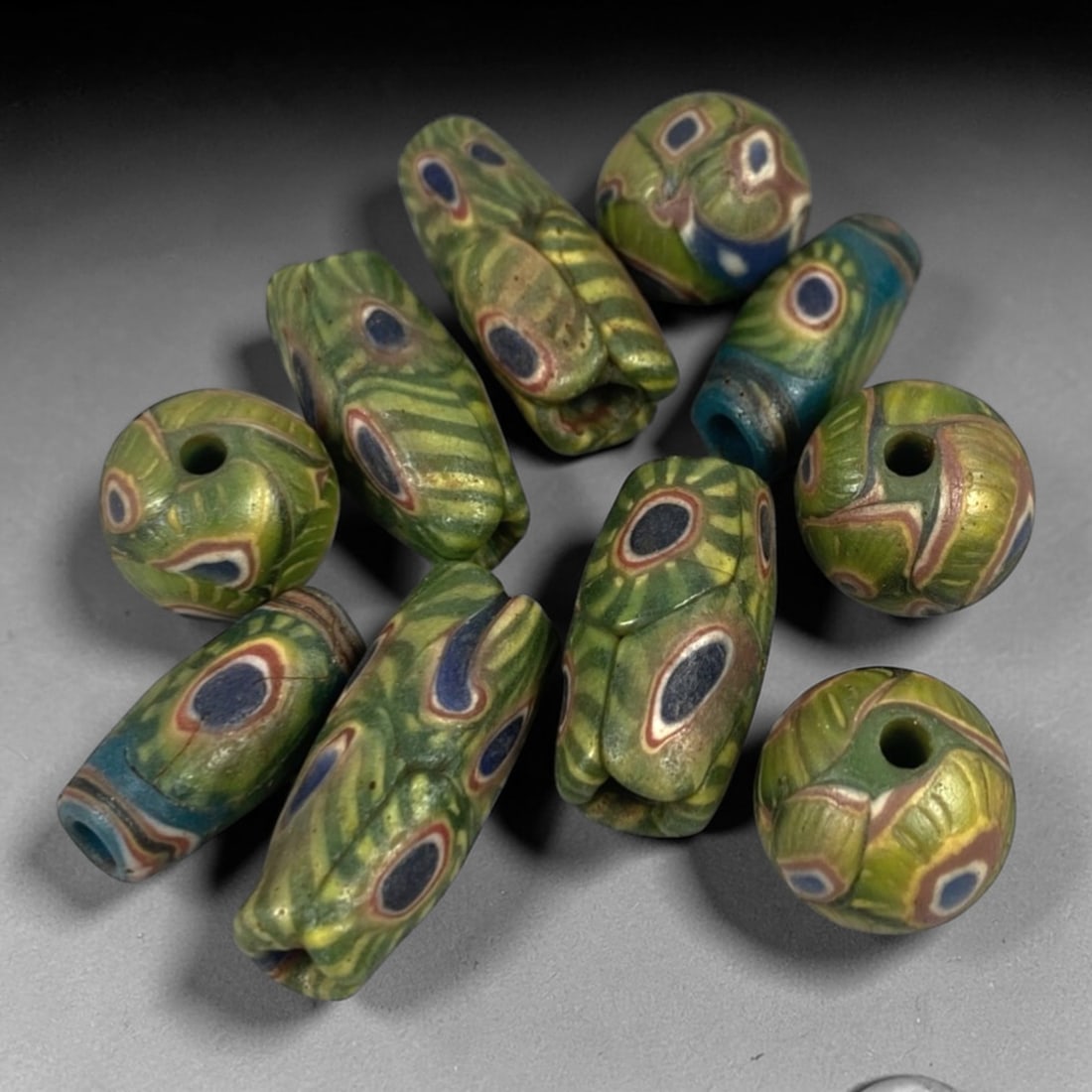 Antique Indo-Himalayan Glass Beads - 10 Pieces, 99FW: This set of 10 antique Indo-Himalayan glass beads features varied forms including cylindrical, barrel, and spherical shapes, crafted from polychrome glass with intricate millefiori and eye-motif patte