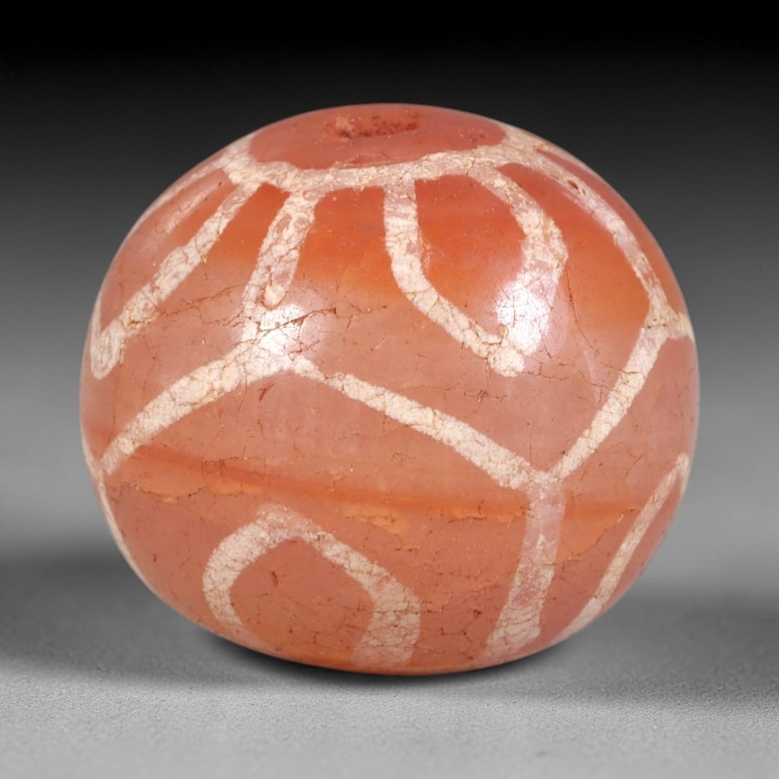 Ancient Carnelian Etched Bead - Himalayan Amulet, 14AS: This ancient spherical bead is crafted from polished carnelian, featuring a rich reddish-brown base with evenly spaced white etched oval motifs across its surface. The bead retains a central drilled s