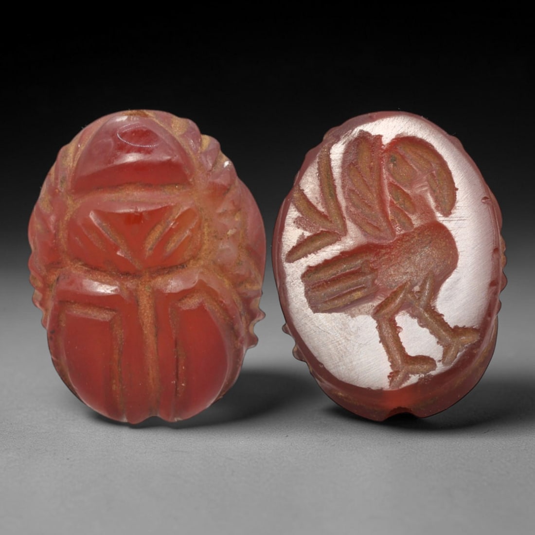 Ancient Carnelian Scarab - Near Eastern Avian Zoomorphic Seal, 17XT: This artifact is hand-carved from translucent deep red carnelian, employing traditional ancient lapidary techniques consistent with Near Eastern Bronze Age seal craftsmanship. The object takes the for