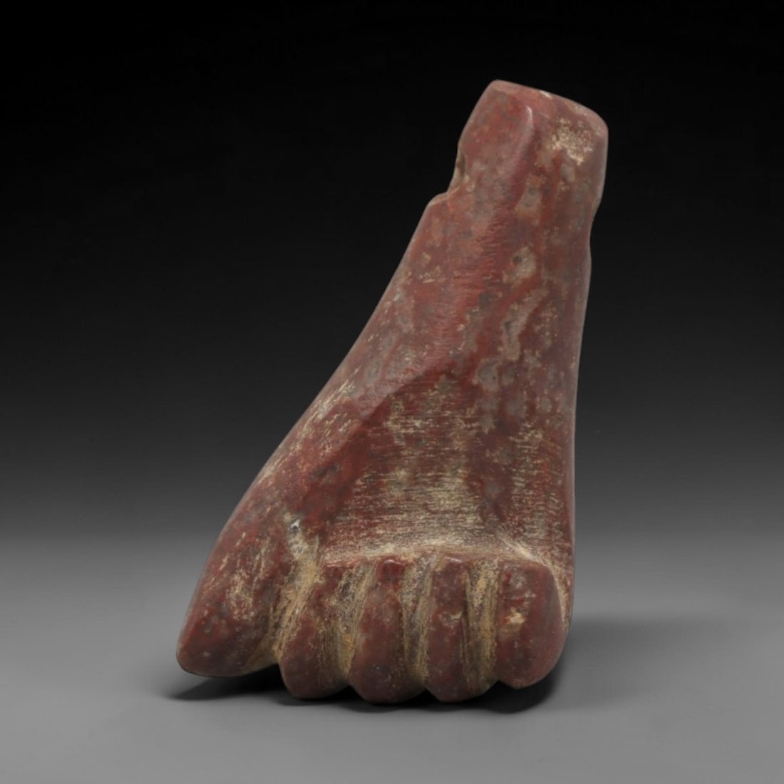 Ancient Egyptian Red Stone Fist Amulet - Carved Pendant Figure, 20ZV: This amulet is carved from a rich, deep red stone with natural mineral speckling and patination, likely brecciated jasper or red steatite, featuring a stylized clenched fist form. The piece displays a
