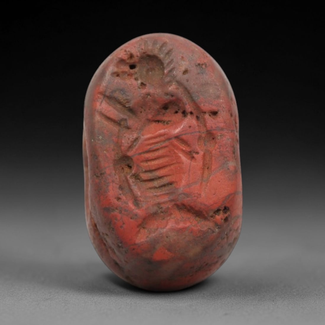 Ancient Stone Hemispherical Stamp Seal - Near Eastern Bird Amulet, 20ZS: This ancient Near Eastern hemispherical stamp seal is carved from a porous, reddish stone, likely brecciated jasper or hematite, with a weathered, earthy patina and natural surface pitting. The seal's