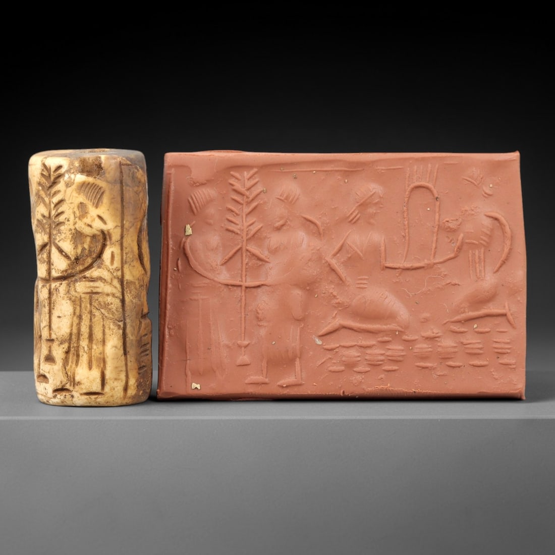 Ancient Steatite Cylinder Seal - Mesopotamian Figural & Narrative Scene, 66AN: Carved from dense steatite, this ancient Mesopotamian cylinder seal features a detailed linear relief composition of multiple human figures in a narrative scene, interwoven with botanical and architec
