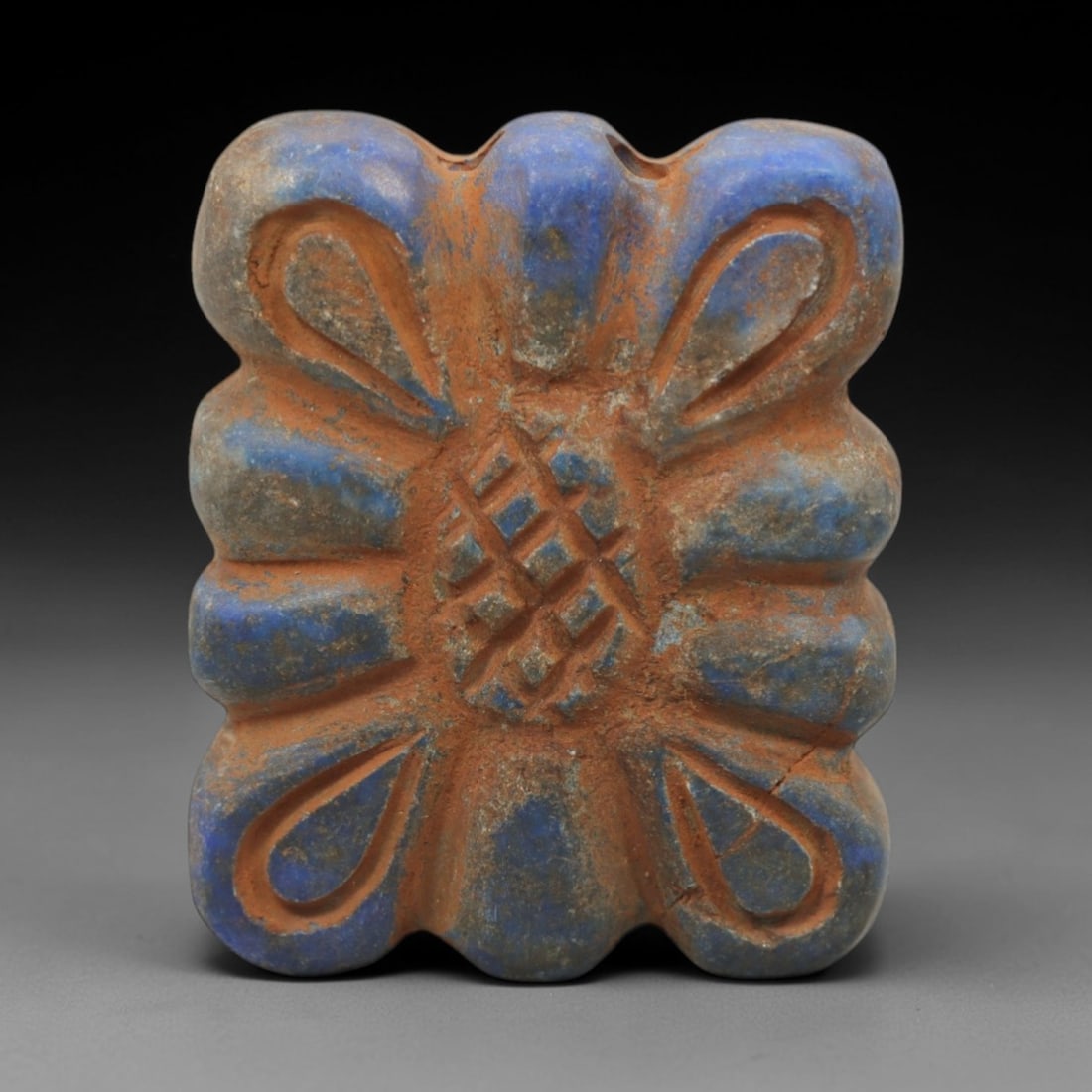 Ancient Lapis Lazuli Amulet - Near Eastern Geometric Motif, 12ZQ: Carved from deep blue lapis lazuli, this amulet features a stylized geometric and foliate motif with incised linear detailing. The stone exhibits natural pyrite inclusions and a subtle, aged patina co