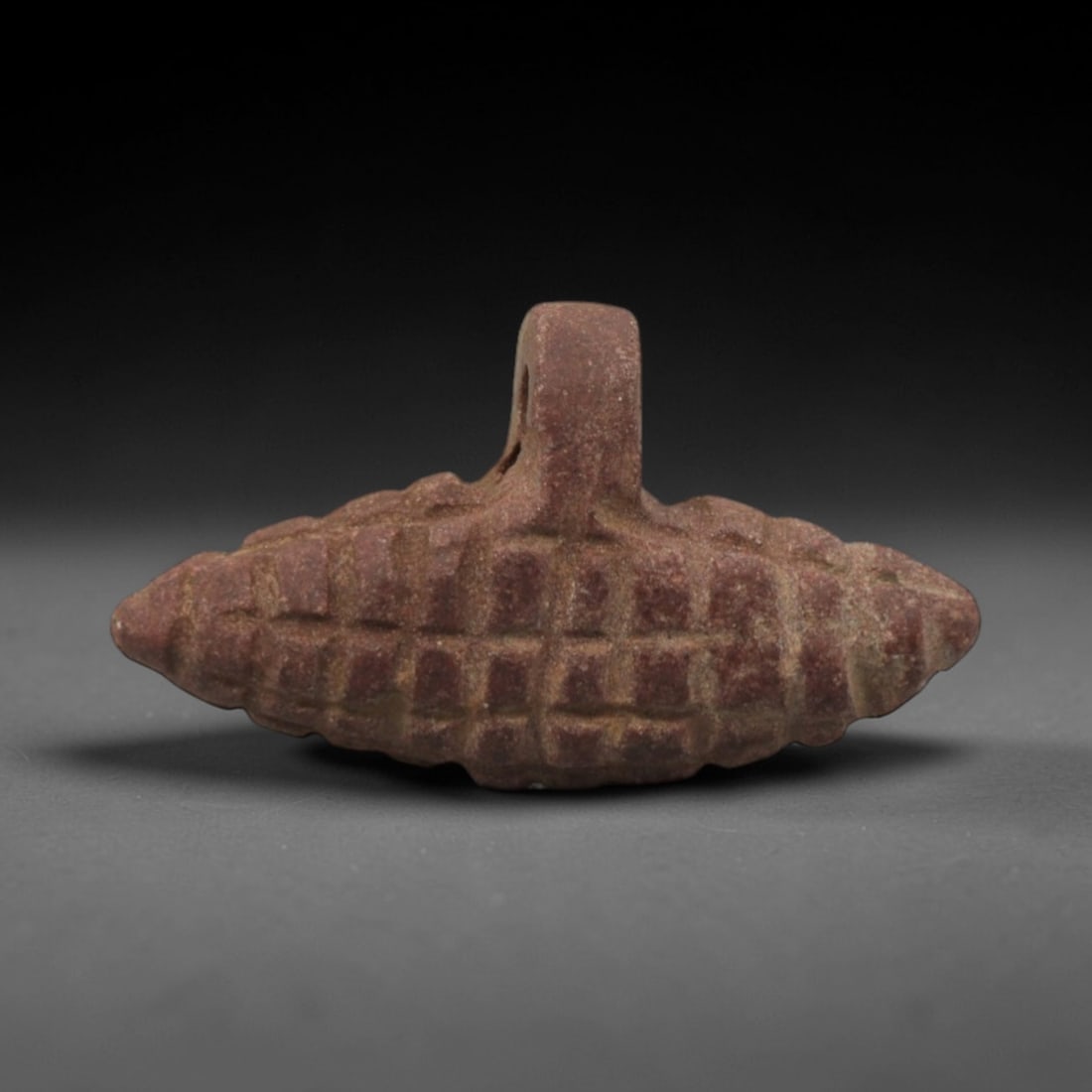 Ancient Stone Cluster Amulet - Egyptian Carved Pendant, 58XR: Carved from reddish-brown stone, this wearable amulet takes the form of a stylized cluster, likely representing a bunch of grapes or a grain sheaf, with a raised suspension loop for threading. The sur