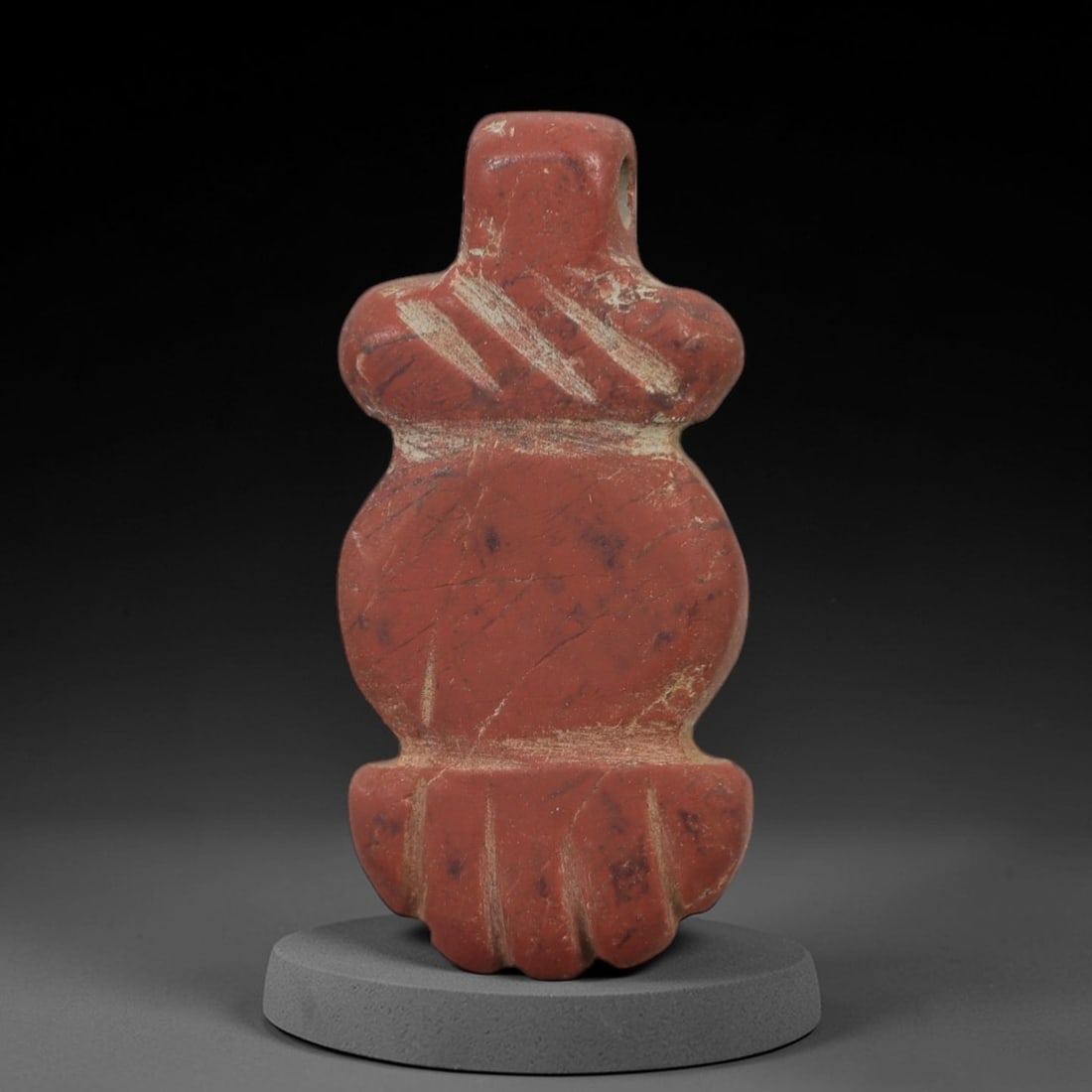 Ancient Stone Tyet Amulet - Egyptian Carved Pendant, 73AG: This amulet is carved from a rich red stone with a weathered, earthy patina and subtle surface fissures. The form is a stylized Tyet (Knot of Isis) amulet, featuring a rectangular upper suspension seg